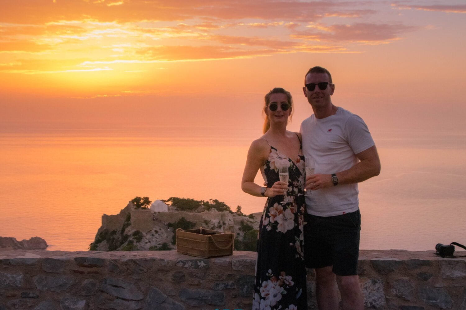 couple enjoying wine during sunset